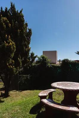 a stone picnic table in a park with a tree at Bella Vista Casa con pileta y terraza in Villa Carlos Paz