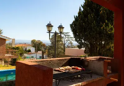 a grill with some food on it on a patio at Bella Vista Casa con pileta y terraza in Villa Carlos Paz
