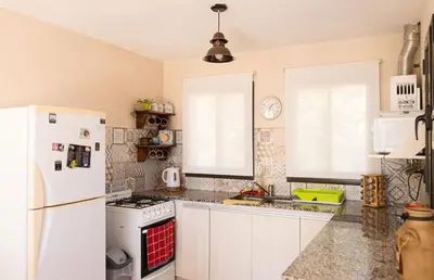 a kitchen with white appliances and a white refrigerator at Bella Vista Casa con pileta y terraza in Villa Carlos Paz