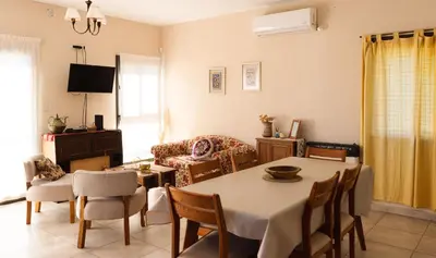 a living room with a table and chairs and a couch at Bella Vista Casa con pileta y terraza in Villa Carlos Paz