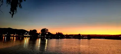 a view of a lake with the sunset in the background at LA PEDRERA - VILLA DEL LAGO - Carlos Paz - Córdoba - Argentina in Villa Carlos Paz