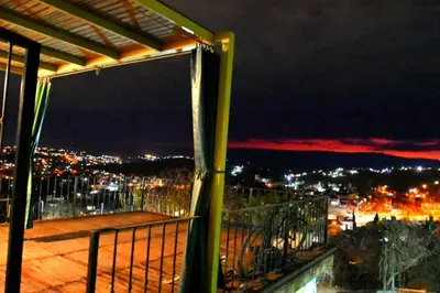 a balcony with a view of a city at night at LA PEDRERA - VILLA DEL LAGO - Carlos Paz - Córdoba - Argentina in Villa Carlos Paz