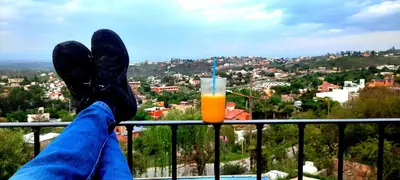 a person with their feet up on a balcony with a drink at LA PEDRERA - VILLA DEL LAGO - Carlos Paz - Córdoba - Argentina in Villa Carlos Paz