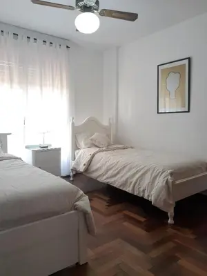 a bedroom with two beds and a ceiling fan at Apartamento Obispo Trejo y Sanabria in Cordoba