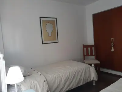a small bedroom with a bed and a chair at Apartamento Obispo Trejo y Sanabria in Cordoba