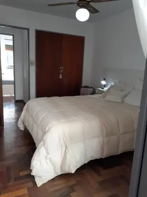 a bedroom with a large white bed with a ceiling fan at Apartamento Obispo Trejo y Sanabria in Cordoba