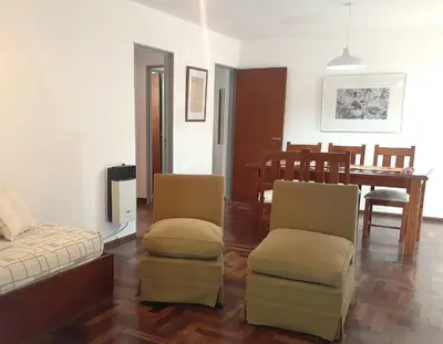 a living room with a bed and chairs and a dining room at Apartamento Obispo Trejo y Sanabria in Cordoba