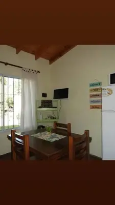 a dining room with a table and chairs and a refrigerator at La Serafina in Los Reartes