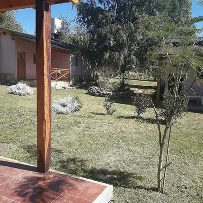 a small tree in a yard next to a house at La Serafina in Los Reartes