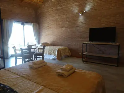 a bedroom with two beds and a flat screen tv at Colina del Valle in Mina Clavero