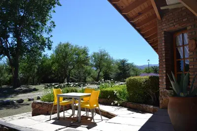 a table and yellow chairs on a patio at Colina del Valle in Mina Clavero
