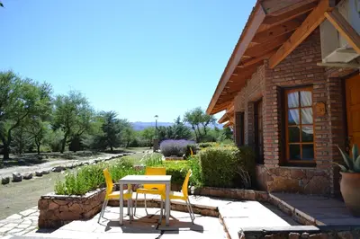 a table and chairs in front of a house at Colina del Valle in Mina Clavero