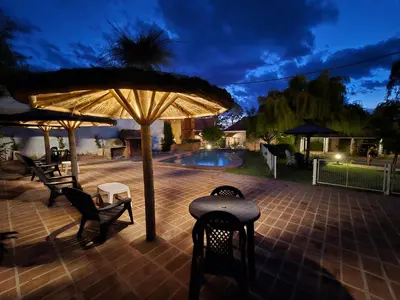 a patio with chairs and an umbrella and a pool at La Margarita Lofts - Solo 2 Adultos in Mina Clavero