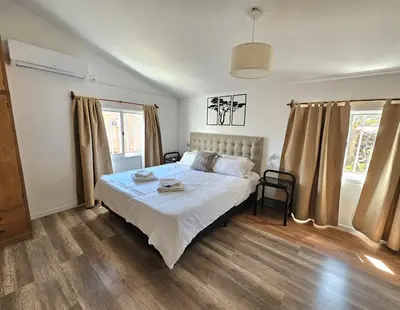 a bedroom with a large bed with white sheets at La Margarita Lofts - Solo 2 Adultos in Mina Clavero