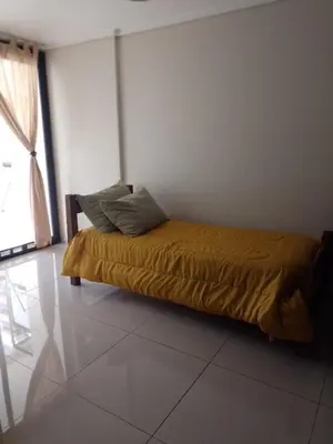 a bedroom with a bed with a yellow blanket and a window at Departamento en Nueva Córdoba - Patagonia 7 in Cordoba
