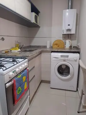 a kitchen with a stove and a washing machine at Departamento en Nueva Córdoba - Patagonia 7 in Cordoba