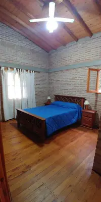 a bedroom with a large bed with a blue blanket at Azul in Arroyo de Los Patos
