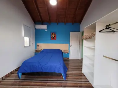a bed in a room with a blue wall at Cabañas San Pío in Merlo