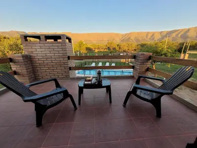 two chairs and a table on a patio with a view at Cabañas San Pío in Merlo