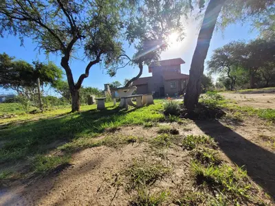 a house in the middle of a field with trees at Cabañas San Pío in Merlo