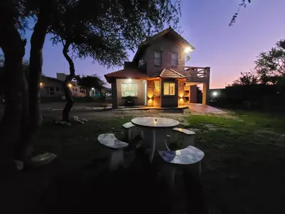 a table in front of a house at night at Cabañas San Pío in Merlo