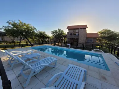 a swimming pool with lounge chairs and a swimming pool at Cabañas San Pío in Merlo