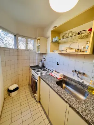 a small kitchen with a sink and a stove at Luminoso departamento con vista! in Cordoba