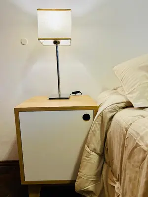 a lamp on a night stand next to a bed at Luminoso departamento con vista! in Cordoba