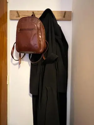 a bag hanging on a door next to a coat at Luminoso departamento con vista! in Cordoba