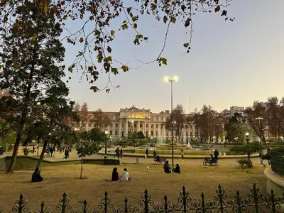 people sitting in a park in front of a building at Luminoso departamento con vista! in Cordoba