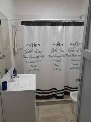 a bathroom with a shower curtain with writing on it at CASA CONFORTABLE II in Cordoba