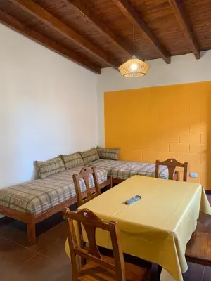 a living room with a bed and a table and chairs at Departamentos Monteolivos in Merlo