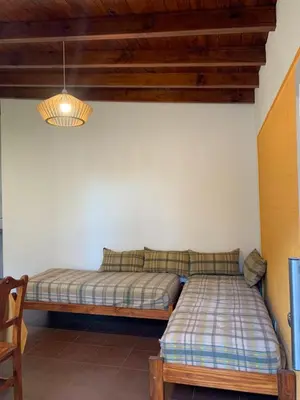 a bed in the corner of a room at Departamentos Monteolivos in Merlo