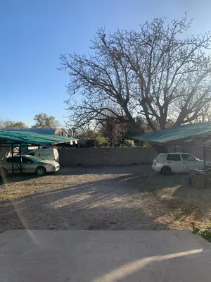 two cars parked in a parking lot with a tent at Departamentos Monteolivos in Merlo