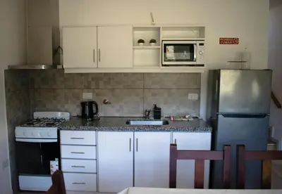 a kitchen with white cabinets and a stove and refrigerator at Monteolivos II in El Rincón