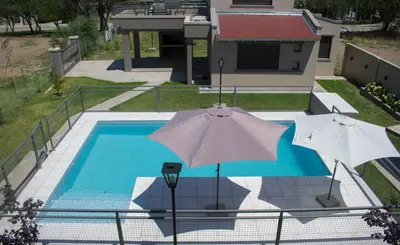two umbrellas are sitting next to a swimming pool at Monteolivos II in El Rincón