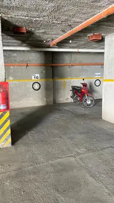 a red motorcycle parked in a parking garage at Edificio Manantiales in Villa Carlos Paz
