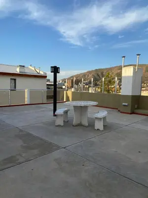 a picnic table and two benches on a roof at Edificio Manantiales in Villa Carlos Paz