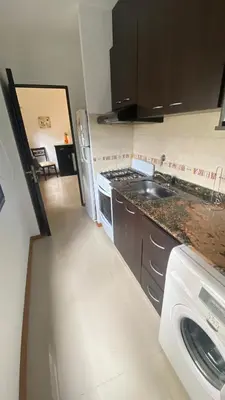 a kitchen with a sink and a stove top oven at Edificio Manantiales in Villa Carlos Paz