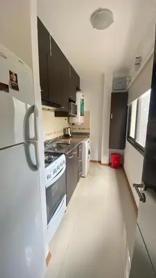 a kitchen with a stove and a refrigerator at Edificio Manantiales in Villa Carlos Paz