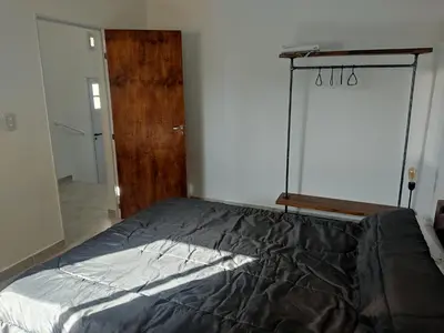 a bedroom with a bed and a wooden door at Villa Aurora in Potrero de Garay