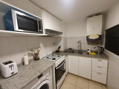 a small kitchen with a stove and a microwave at LOAN Nueva Cordoba 6A in Cordoba