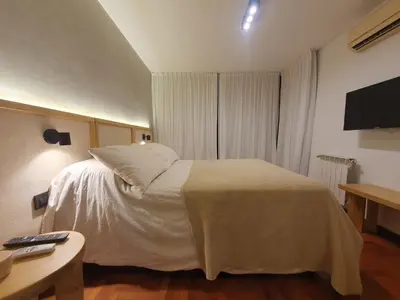 a bedroom with a white bed and a television at LOAN Nueva Cordoba 6A in Cordoba