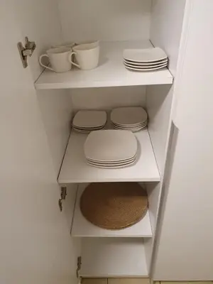 a white shelf with plates and cups and bowls at LOAN Nueva Cordoba 6A in Cordoba
