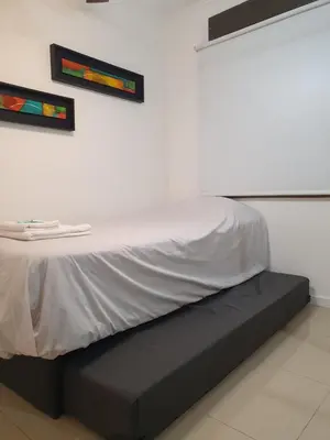 a bed with a white sheet on top of it at LOAN Nueva Cordoba 9E in Cordoba