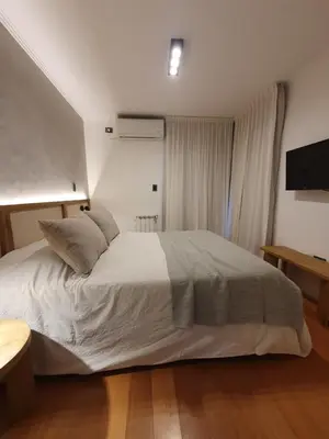 a bedroom with a white bed and a television at LOAN Nueva Cordoba categoría appart 7B in Cordoba