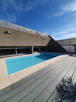a swimming pool on top of a building with a wooden deck at LOAN Nueva Cordoba categoría appart 7B in Cordoba