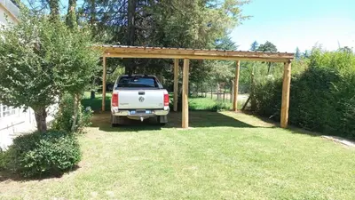 a truck parked under a wooden pergola in a yard at Cabañas Titina's Lake in Potrero de Garay