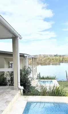a house with a swimming pool next to a lake at Cabañas Titina's Lake in Potrero de Garay