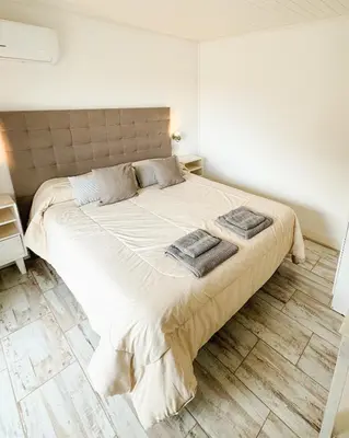a bedroom with a large bed with two towels on it at Cabañas Titina's Lake in Potrero de Garay